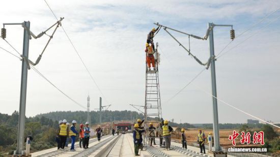 10月29日,施工人员在昌九高铁昌北机场站附近进行承力索架设悬挂点固定。张杰 摄.jpg 10月29日,施工人员在昌九高铁昌北机场站附近进行承力索架设悬挂点固定。张杰 摄.jpg