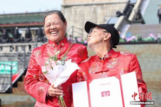 图为江西南昌滕王阁景区第八届金婚盛典活动现场,一对金婚老人展示他们的金婚证书。 刘思伟 摄.jpeg 图为江西南昌滕王阁景区第八届金婚盛典活动现场,一对金婚老人展示他们的金婚证书。 刘思伟 摄.jpeg
