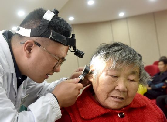 图为专业技术人员正在为有着中重度听损的村民何南枝细心检查耳内情况等.jpg 图为专业技术人员正在为有着中重度听损的村民何南枝细心检查耳内情况等.jpg