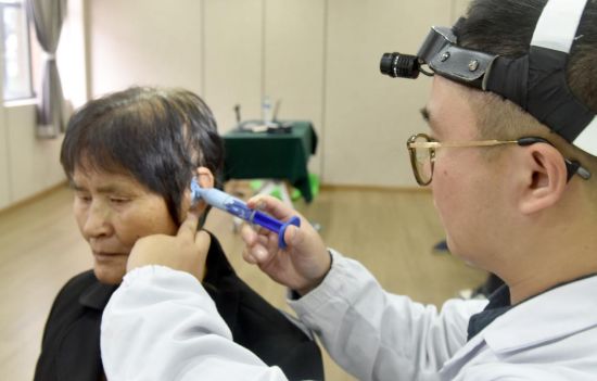 图为专业技术人员正在为有着严重听力残疾的乐平市接渡镇子安社区村民李五妹细心免费的专业听力测试、助听器适配和取模等服务。.jpg 图为专业技术人员正在为有着严重听力残疾的乐平市接渡镇子安社区村民李五妹细心免费的专业听力测试、助听器适配和取模等服务。.jpg