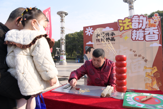 非遗普法糖画摊位匠人帮群众画糖画 非遗普法糖画摊位匠人帮群众画糖画