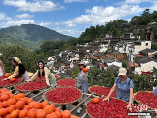 9月23日,在江西婺源篁岭古村,游客正在晒架前打卡拍照。李韵涵 摄 9月23日,在江西婺源篁岭古村,游客正在晒架前打卡拍照。李韵涵 摄
