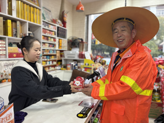 图为董雨情给环卫工老刘送上“平安果” 图为董雨情给环卫工老刘送上“平安果”