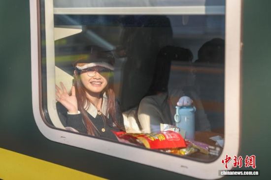 12月31日,江西南昌站,旅客谈同学坐在车厢里,她和朋友准备乘车前往江西鹰潭游玩。中新社记者 刘力鑫 摄 12月31日,江西南昌站,旅客谈同学坐在车厢里,她和朋友准备乘车前往江西鹰潭游玩。中新社记者 刘力鑫 摄