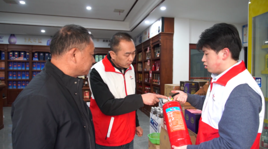 图为安全服务小队成员为零售户讲解灭火器压力识别知识 图为安全服务小队成员为零售户讲解灭火器压力识别知识