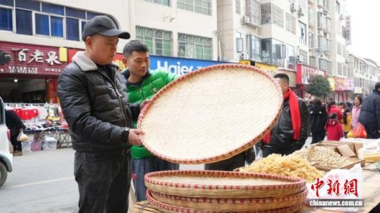 图为江西省九江市修水县山口镇的年集上,农户在选购年货。余星 摄 图为江西省九江市修水县山口镇的年集上,农户在选购年货。余星 摄