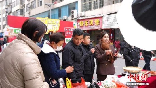 图为江西省九江市修水县山口镇的年集上,主播在直播推介当地农特产品。余星 摄 图为江西省九江市修水县山口镇的年集上,主播在直播推介当地农特产品。余星 摄