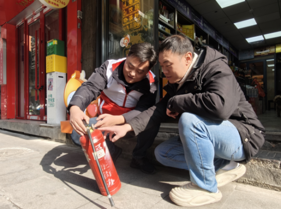 图为西湖区烟草专卖局平安志愿者邓伟与零售客户涂振毅共同查看消防灭火器的压力情况。 图为西湖区烟草专卖局平安志愿者邓伟与零售客户涂振毅共同查看消防灭火器的压力情况。