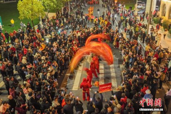 图为巡游现场,精彩的表演吸引众多民众沿街观看。(无人机照片)中新社记者 刘力鑫 摄 图为巡游现场,精彩的表演吸引众多民众沿街观看。(无人机照片)中新社记者 刘力鑫 摄