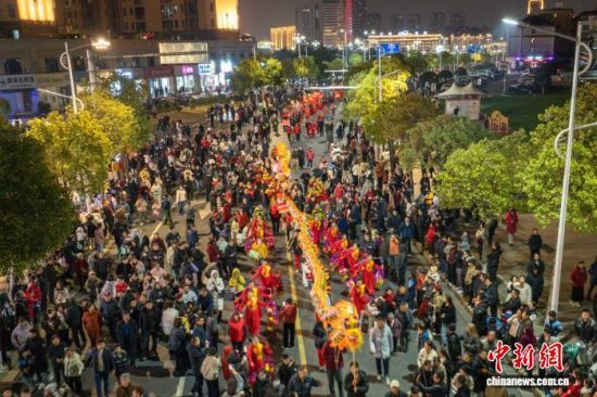 图为巡游现场,精彩的表演吸引众多民众沿街观看。(无人机照片)中新社记者 刘力鑫 摄 图为巡游现场,精彩的表演吸引众多民众沿街观看。(无人机照片)中新社记者 刘力鑫 摄