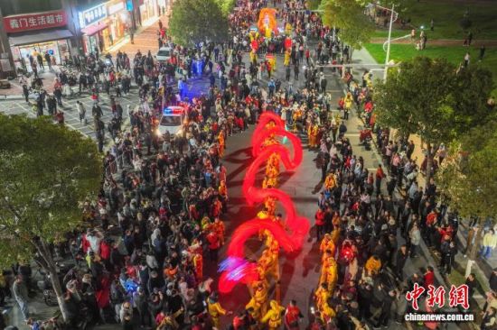 图为巡游现场,精彩的表演吸引众多民众沿街观看。(无人机照片)中新社记者 刘力鑫 摄 图为巡游现场,精彩的表演吸引众多民众沿街观看。(无人机照片)中新社记者 刘力鑫 摄