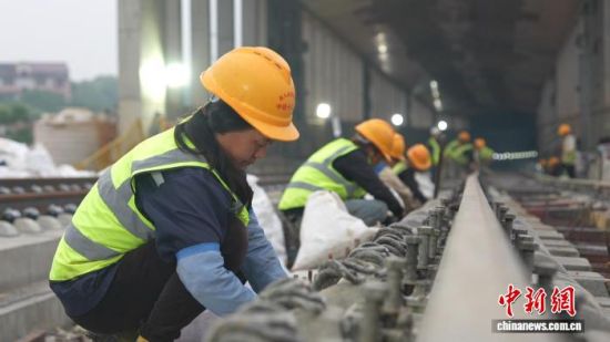 图为昌九高铁无砟轨道混凝土浇筑施工现场,施工人员对轨道钢筋进行捆扎作业。刘述鹏 摄 图为昌九高铁无砟轨道混凝土浇筑施工现场,施工人员对轨道钢筋进行捆扎作业。刘述鹏 摄