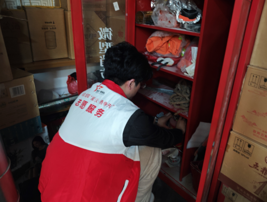 图为平安志愿者检查零售户店里微型消防站内应急救援设施(舒佳莹 摄) 图为平安志愿者检查零售户店里微型消防站内应急救援设施(舒佳莹 摄)