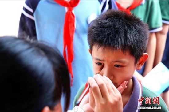 6月15日,在江西省九江市德安县博物馆,学生体验额头画“王”等民俗。陈耀翔 摄 6月15日,在江西省九江市德安县博物馆,学生体验额头画“王”等民俗。陈耀翔 摄