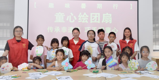 图为该镇志愿者正与孩子们一道向人们展示绘画成果。.png 图为该镇志愿者正与孩子们一道向人们展示绘画成果。.png