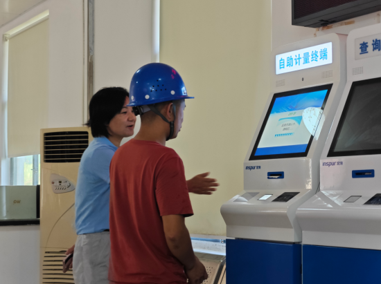 图为工作人员帮助客户使用自助检斤系统。 图为工作人员帮助客户使用自助检斤系统。