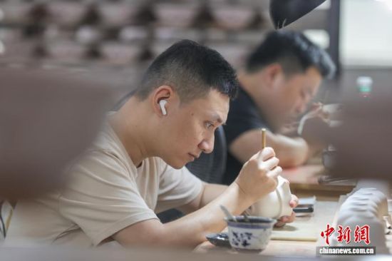7月7日,工匠在景德镇进行手绘工序,在坯体上绘制各种花面图案。 刘力鑫 摄 7月7日,工匠在景德镇进行手绘工序,在坯体上绘制各种花面图案。 刘力鑫 摄