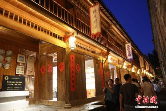 7月30日晚,游客在江西景德镇镇区瓷业店铺建筑一一毕家上弄红店旧址前拍照。中新社记者 刘占昆 摄 7月30日晚,游客在江西景德镇镇区瓷业店铺建筑一一毕家上弄红店旧址前拍照。中新社记者 刘占昆 摄