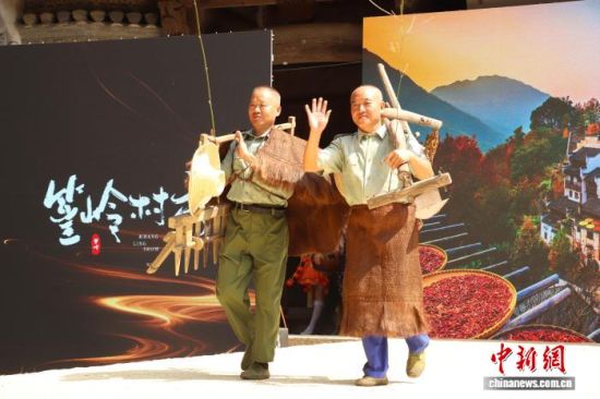 图为篁岭古村第十二届篁岭晒秋文化季开幕式现场,村民们身着农耕服饰,手持传统农具在T台上走秀。 熊锦阳 摄 图为篁岭古村第十二届篁岭晒秋文化季开幕式现场,村民们身着农耕服饰,手持传统农具在T台上走秀。 熊锦阳 摄