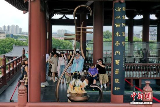 8月13日,航拍江西九江长江国家文化公园的琵琶亭,游客排队在琵琶亭内的琵琶雕塑前拍照打卡。 中新社记者 刘占昆 摄 8月13日,航拍江西九江长江国家文化公园的琵琶亭,游客排队在琵琶亭内的琵琶雕塑前拍照打卡。 中新社记者 刘占昆 摄
