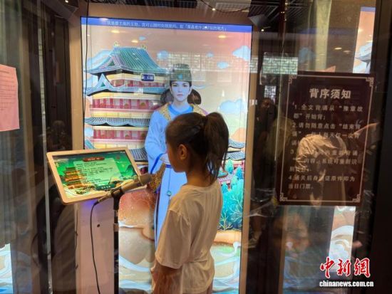 8月11日,游客正在滕王阁景区内背诵《滕王阁序》,虚拟数字人“王勃”为游客背诵打分。中新社记者 李韵涵 摄 8月11日,游客正在滕王阁景区内背诵《滕王阁序》,虚拟数字人“王勃”为游客背诵打分。中新社记者 李韵涵 摄