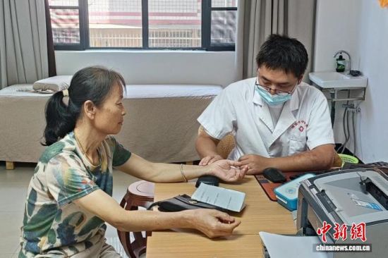 图为在江西省瑞金市中医院治未病科诊室,该院中医师钟久幸为患者诊脉。吴思雨 摄 图为在江西省瑞金市中医院治未病科诊室,该院中医师钟久幸为患者诊脉。吴思雨 摄