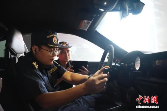 图为赣州海关工作人员正在查验享受“两证合一”优惠政策的进口车辆。王志飞 摄 图为赣州海关工作人员正在查验享受“两证合一”优惠政策的进口车辆。王志飞 摄