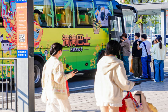 图为乘客排队乘坐滴滴站点巴士“五彩之心”号。 图为乘客排队乘坐滴滴站点巴士“五彩之心”号。